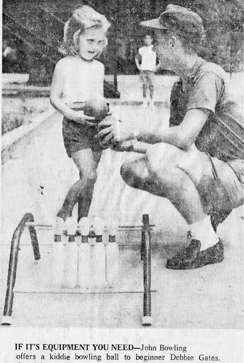 A man shows a child how to bowl